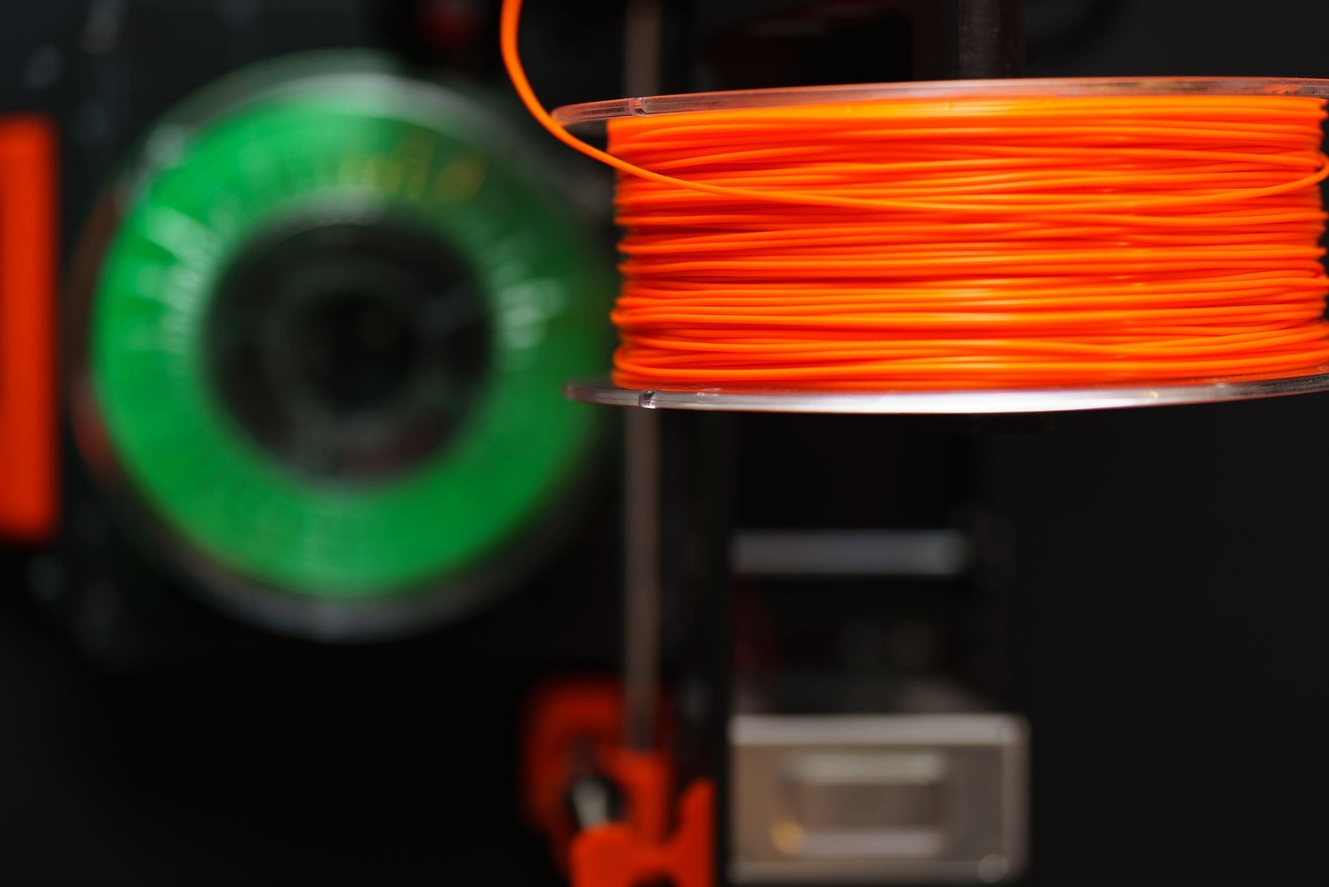 ม้วนเส้น Filament สีส้มบนเครื่องพิมพ์ 3D สำหรับงานพิมพ์ PETG