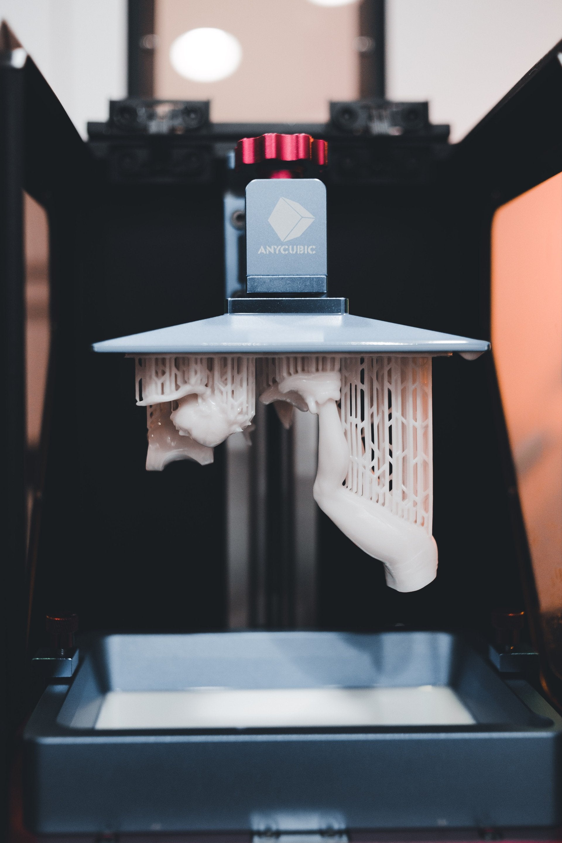 เครื่องพิมพ์ 3D เรซิ่น Anycubic กำลังยกแท่นพิมพ์ขึ้นจากอ่างเรซิ่น เห็นชิ้นงานพร้อม support
